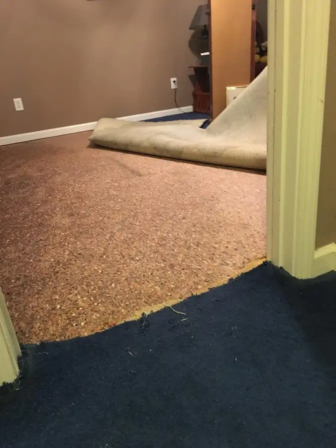 Carpet pad removal revealing water damage during Water Mitigation Services in Myrtle Grove